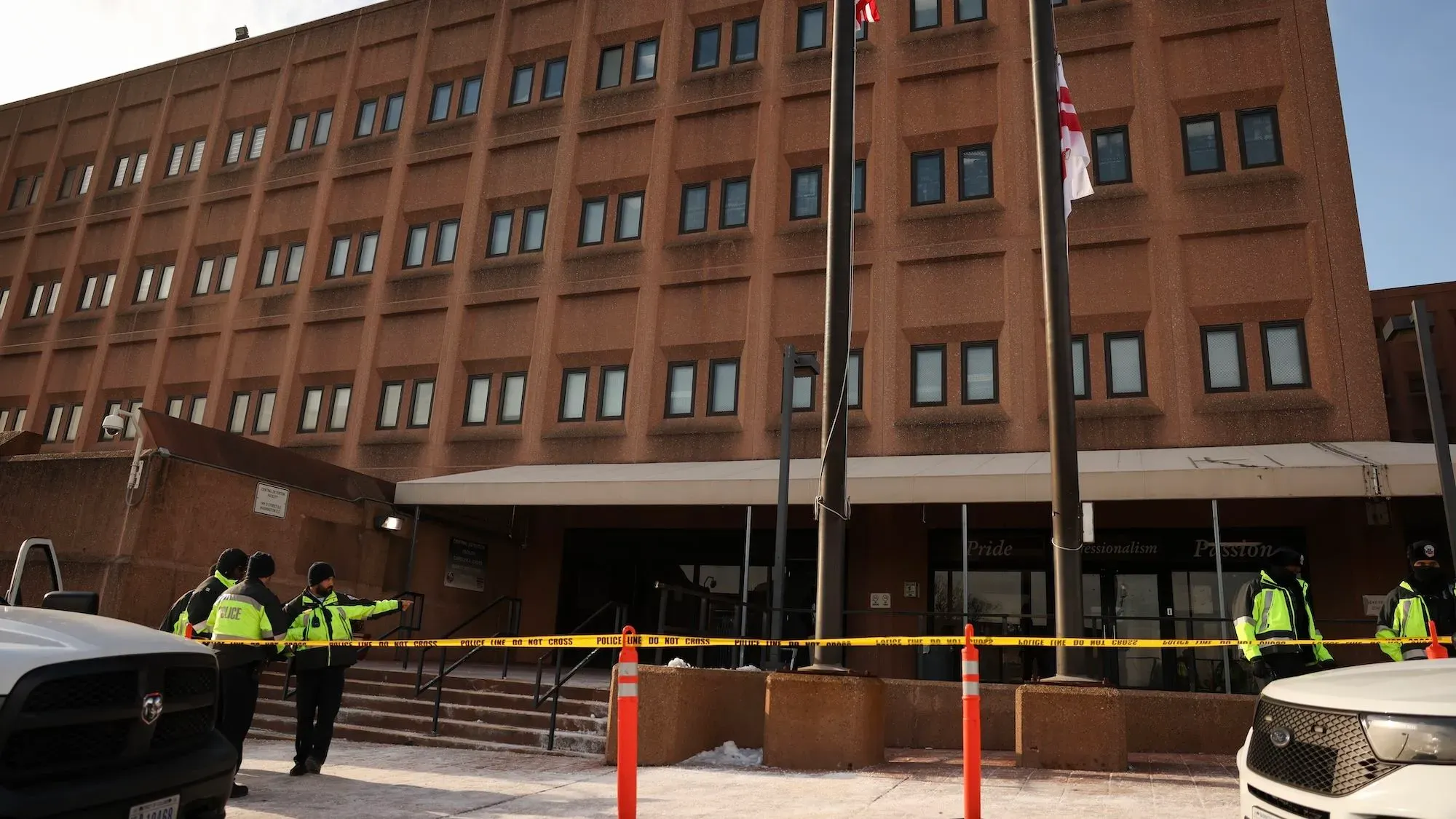 مبنى سجن في واشنطن العاصمة، حيث يتواجد أفراد الشرطة عند المدخل، مع شريط تحذيري يمنع الاقتراب.