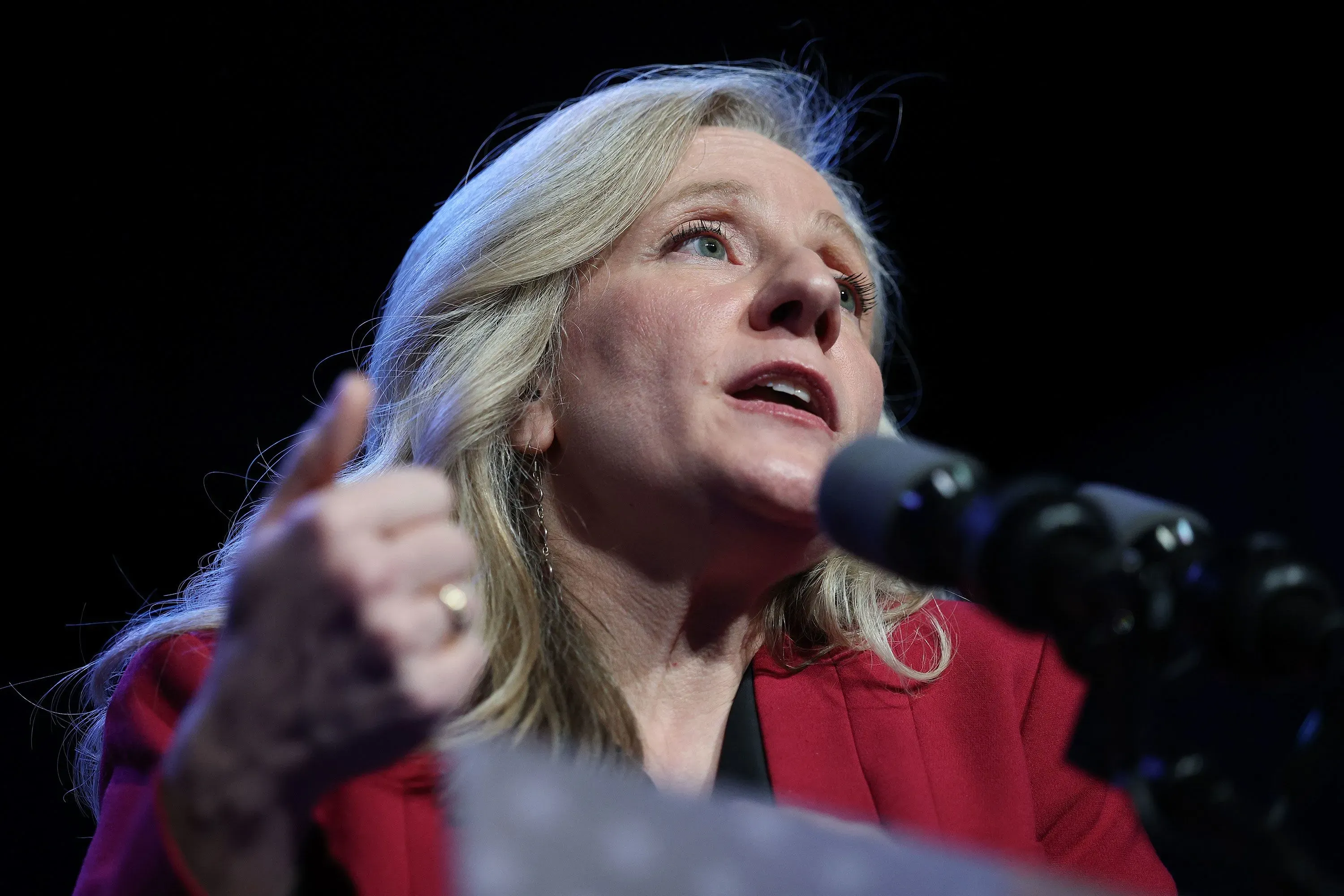 امرأة تتحدث في مؤتمر صحفي، معبرة عن آرائها حول إعادة تقسيم الدوائر الانتخابية في فرجينيا، في ظل التوترات السياسية الحالية.