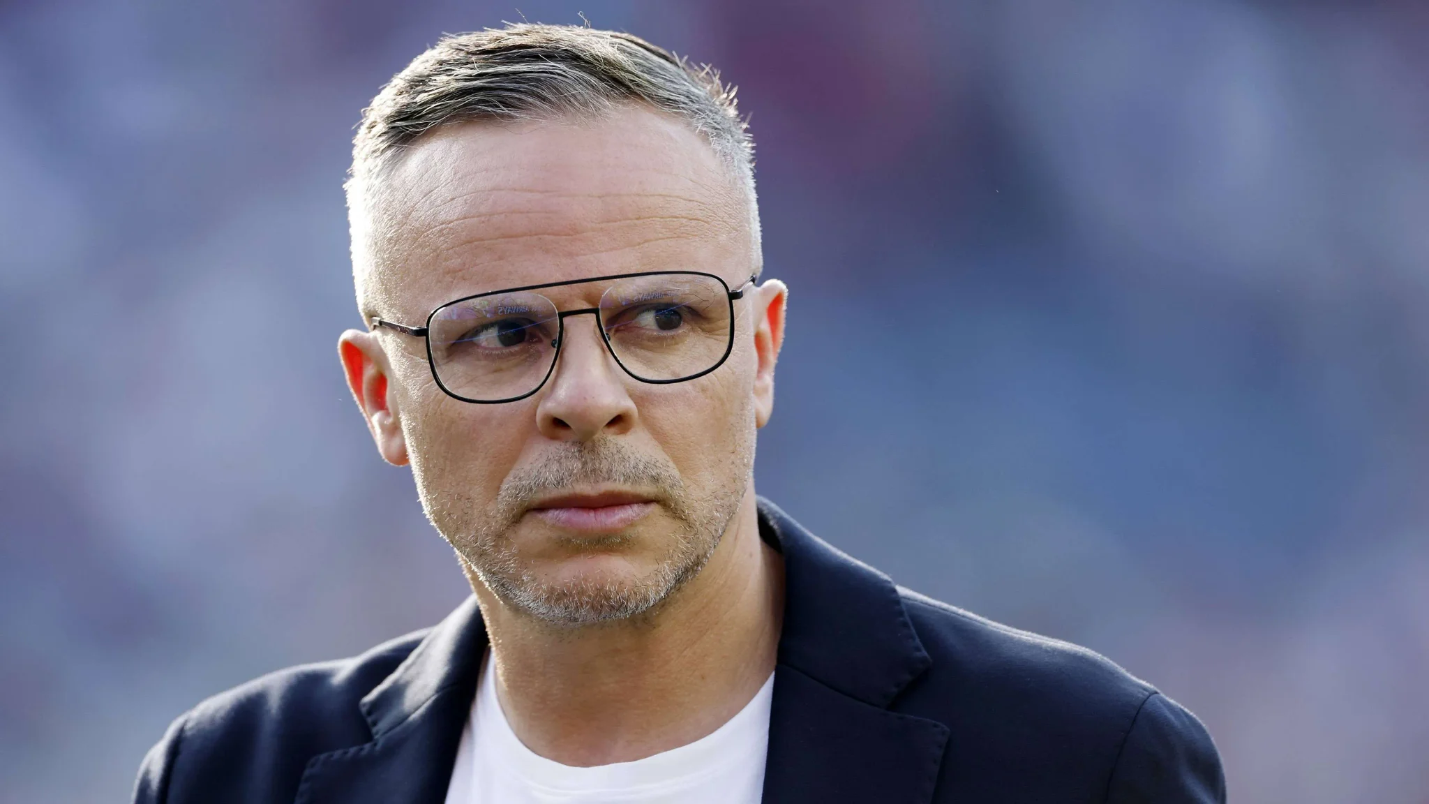 المدرب المغربي محمد وهبي يرتدي نظارات ويبدو مركزاً خلال مهمة إقناع لاعب ريال مدريد الشاب Thiago Pitarch بتمثيل المغرب.