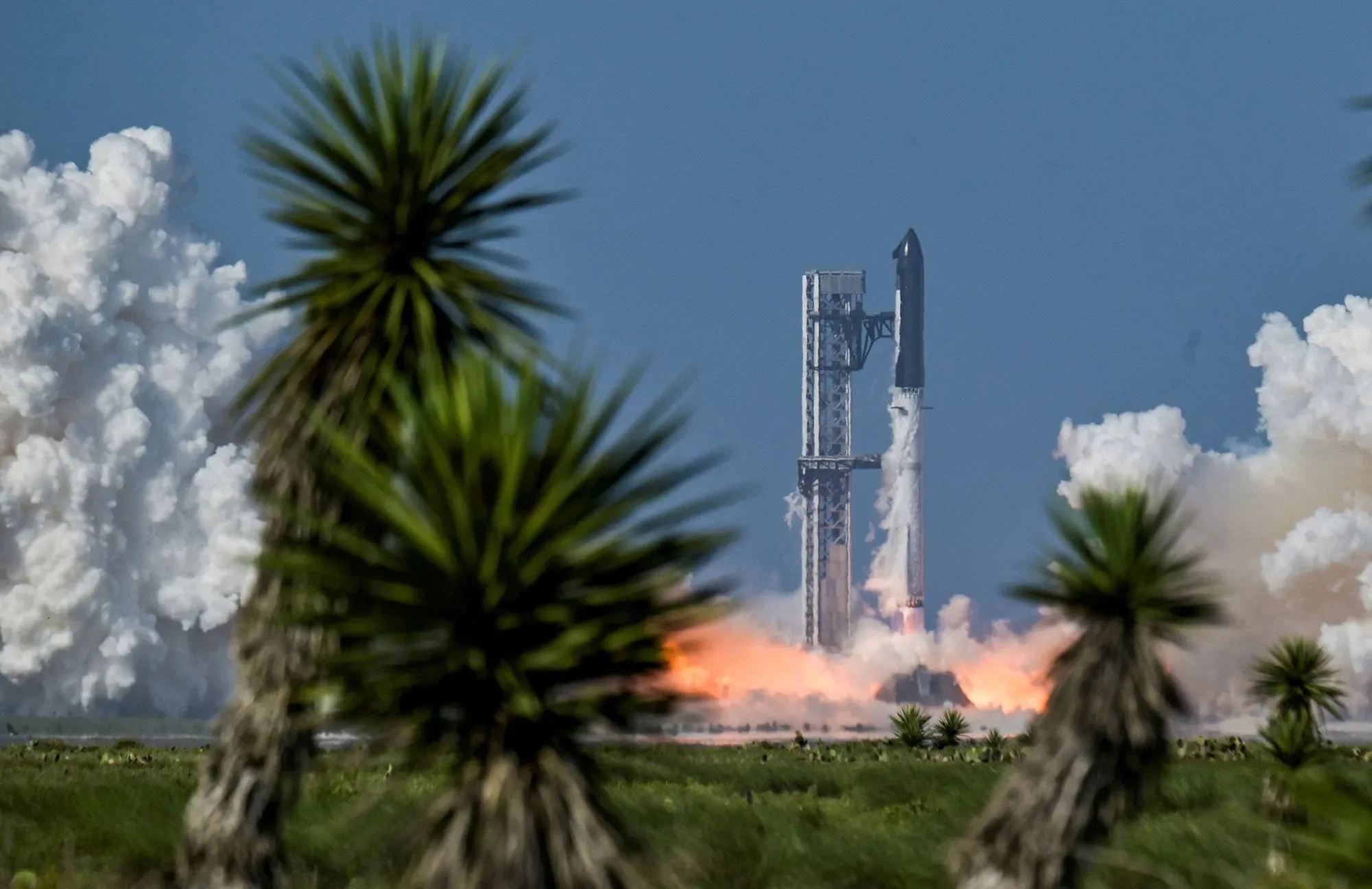 صاروخ SpaceX ينطلق من منصة الإطلاق وسط دخان ونيران، مع تركيز على تقلبات سهم الشركة وتقرير أرباحها الفصلية.