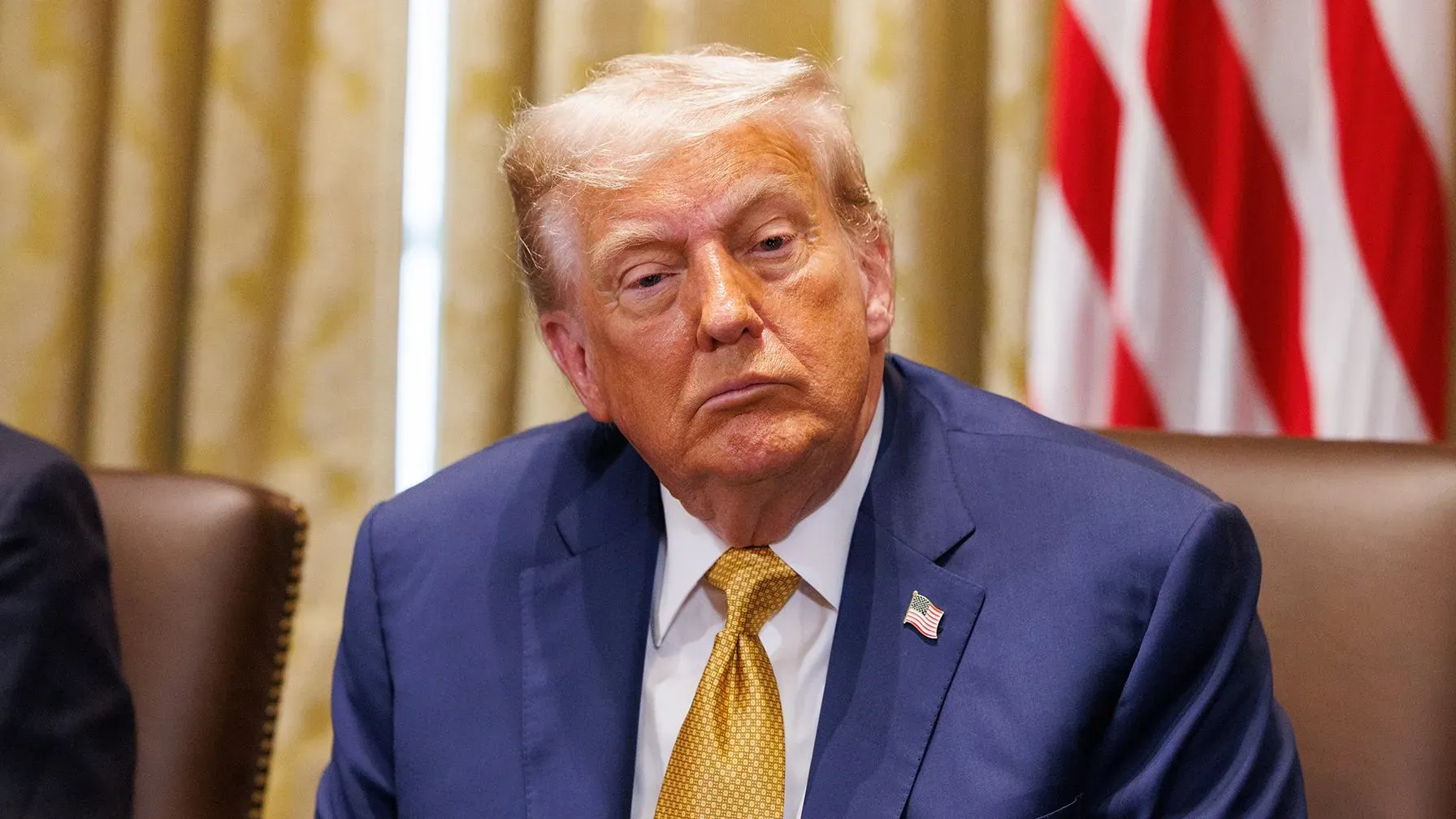 الرئيس الأمريكي السابق دونالد ترامب خلال اجتماع، مع تعبير جاد، في سياق مناقشة التعريفات الجمركية وتأثيرها على الأسواق.