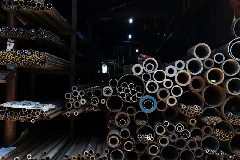 أنابيب معدنية متنوعة موضوعة في مستودع، تعكس تأثير التعريفات الجمركية على التجارة، مع تراجع صادرات كوريا الجنوبية.