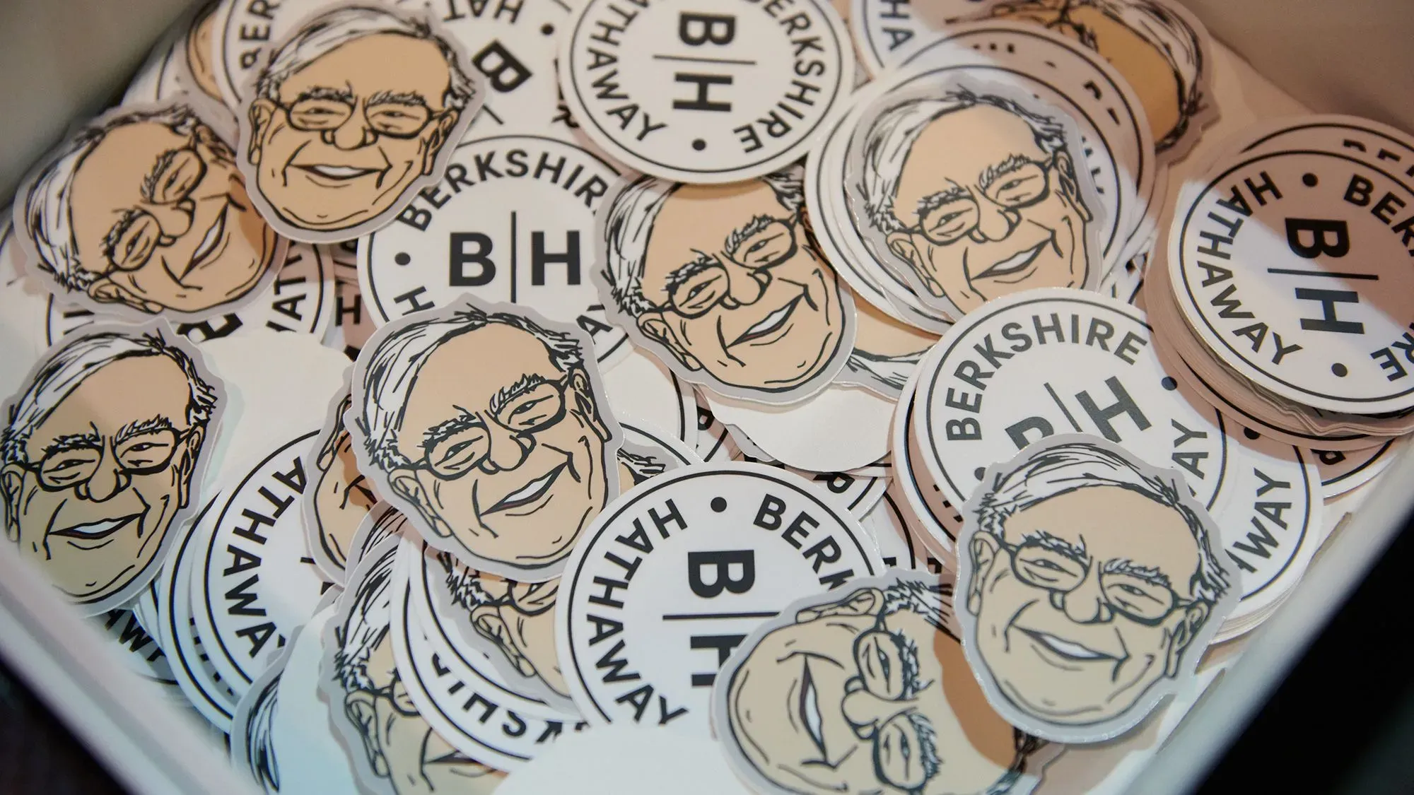 ملصقات تحمل صورة مبتكرة لوارين بافيت، الرئيس التنفيذي لشركة بيركشاير هاثاواي، تظهر في حفل سنوي للمستثمرين.