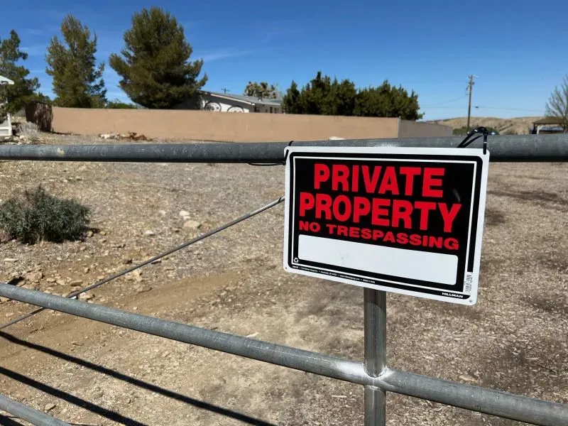لافتة على بوابة معدنية تشير إلى ملكية خاصة وتحذر من التعدي، في منطقة ريفية بكاليفورنيا، حيث يثير إطلاق سراح مجرم جنسي قلق السكان.