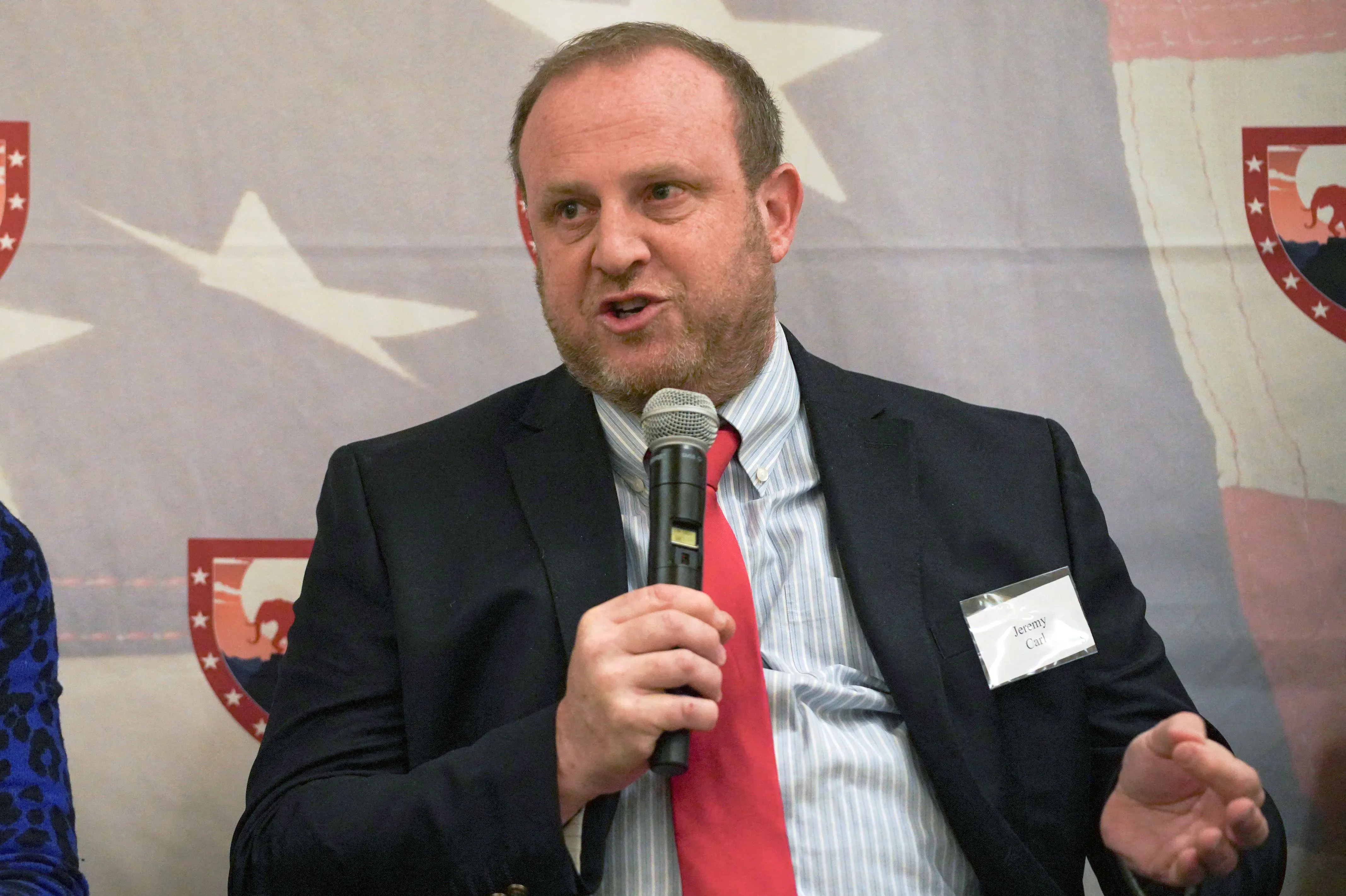 جيريمي كارل يتحدث في حدث سياسي، مع التركيز على خطابه التحريضي وأثره على ترشيحه لمنصب مساعد وزير الخارجية.