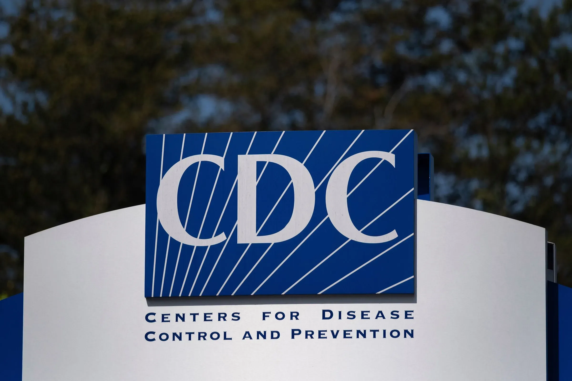 شعار مراكز السيطرة على الأمراض والوقاية منها (CDC) يظهر بوضوح، مع خلفية طبيعية، في سياق التغييرات القيادية والاضطرابات الصحية.