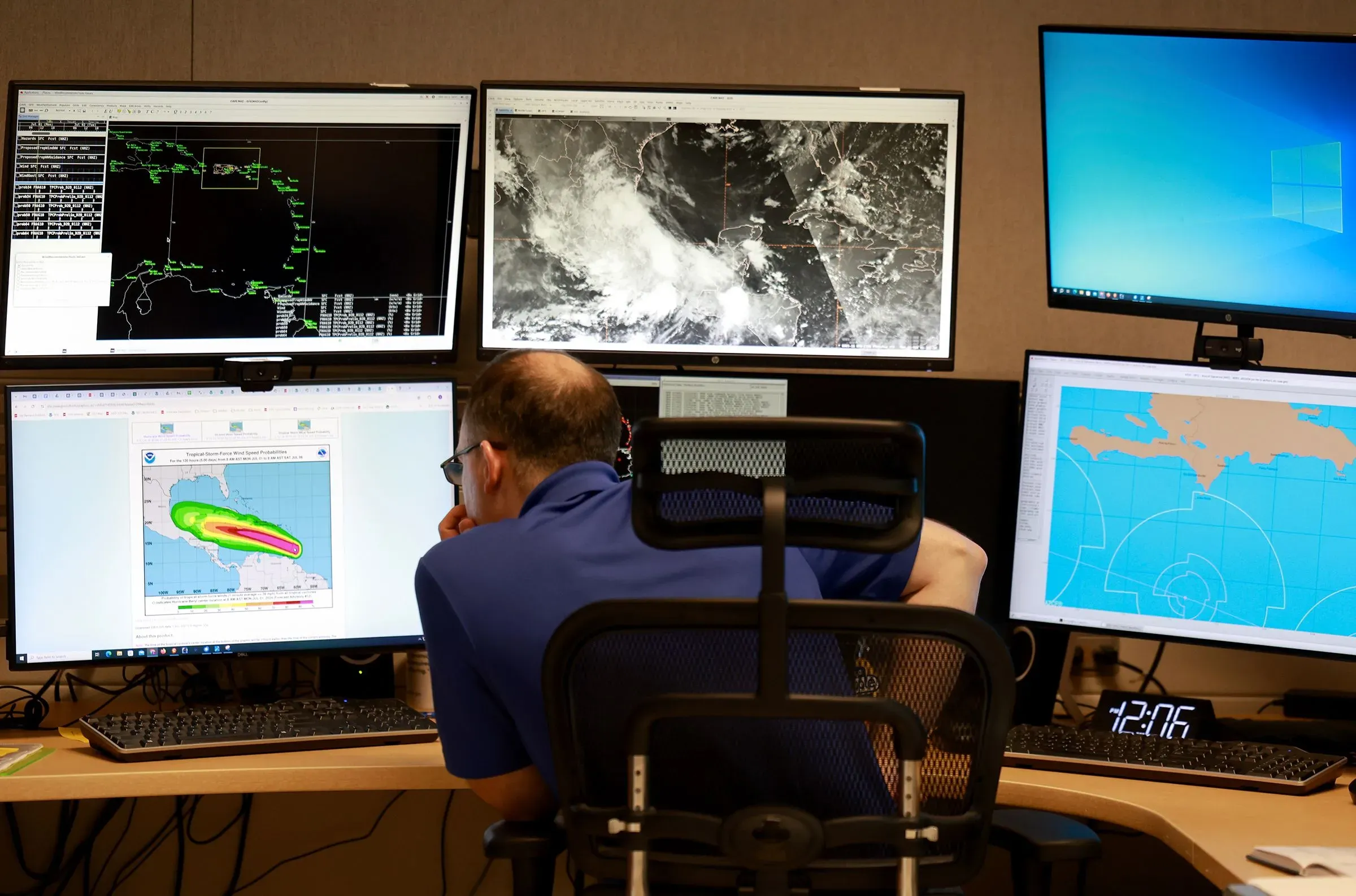 موظف في مركز الأرصاد الجوية يتابع بيانات الطقس على شاشات متعددة، استعدادًا لموسم الأعاصير في المحيط الأطلسي.