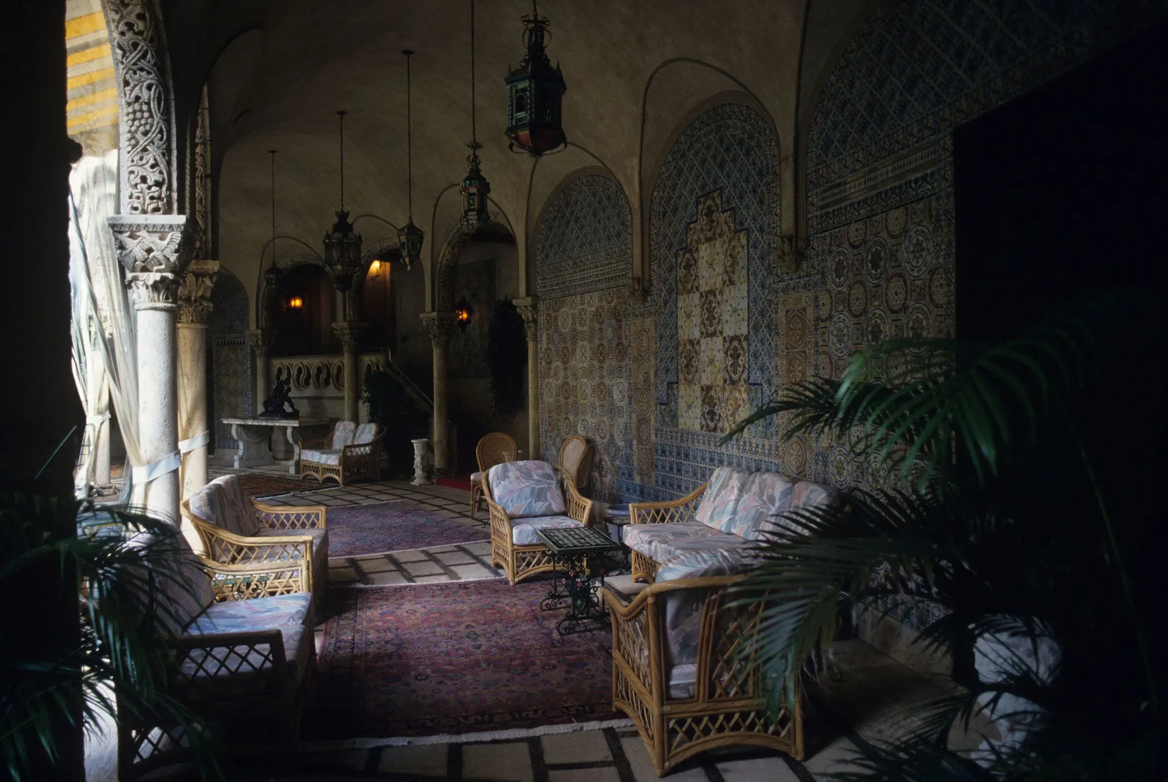 تصميم داخلي أنيق في قاعة استقبال مزينة بالفسيفساء، مع أثاث مريح وأضواء دافئة، يعكس أسلوب ترامب في التجديد والبناء.