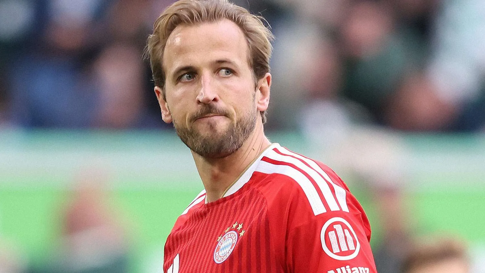 هاري كين يرتدي قميص بايرن ميونخ الأحمر خلال مباراة، مع تركيز على أدائه المميز في الدوري الألماني وموسم 2025-26.