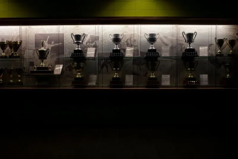 عرض لجوائز وكؤوس الهوكي في متحف، مع إضاءة خافتة، تعكس تاريخ اللعبة وعراقتها في المجتمع الكندي.