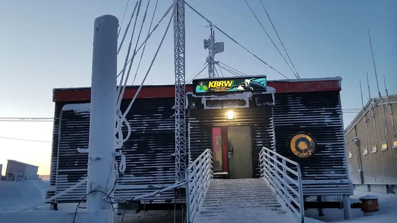 مبنى محطة KBRW الإذاعية في ألاسكا، محاط بالثلوج، يمثل مصدرًا حيويًا للمعلومات للمجتمعات المحلية في ظل تهديدات التمويل.