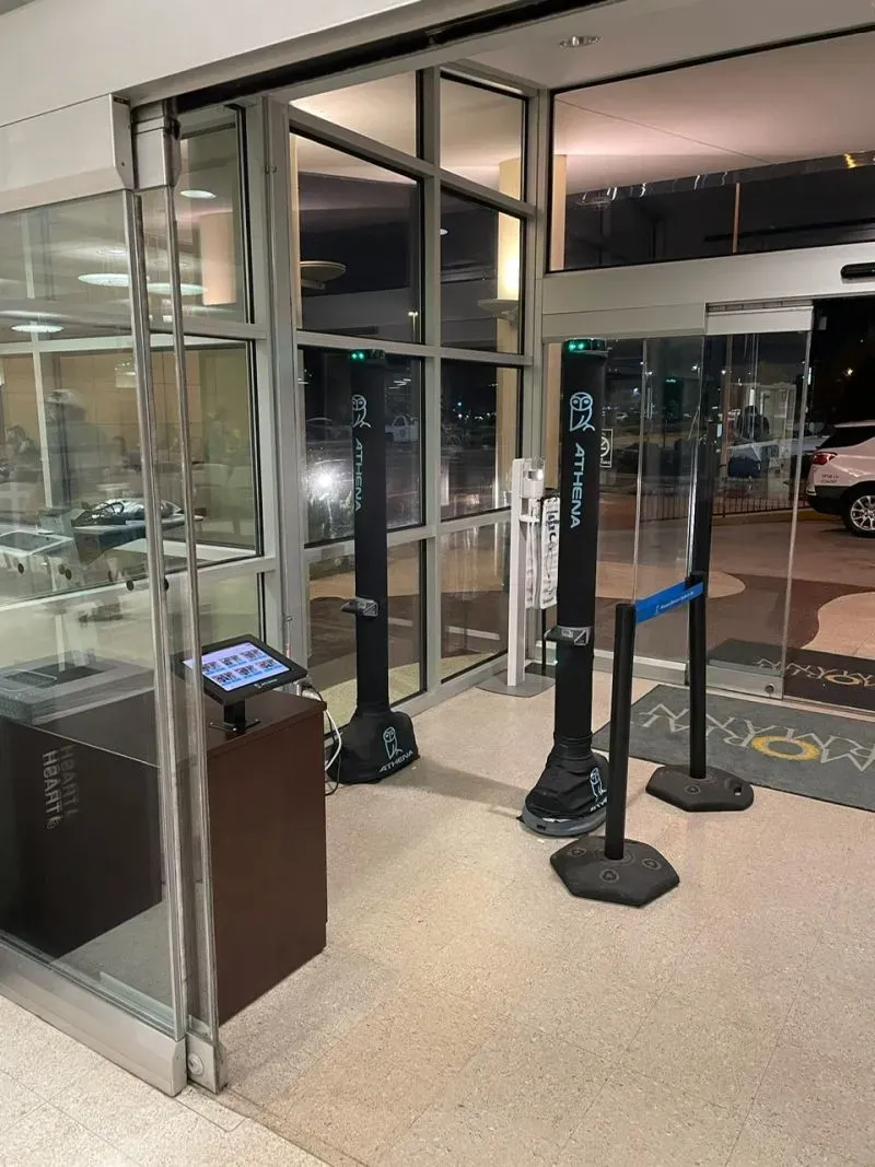 مدخل مستشفى مزود بأجهزة أمان حديثة، بما في ذلك بوابات إلكترونية وكاميرات، لتعزيز سلامة العاملين والمرضى.