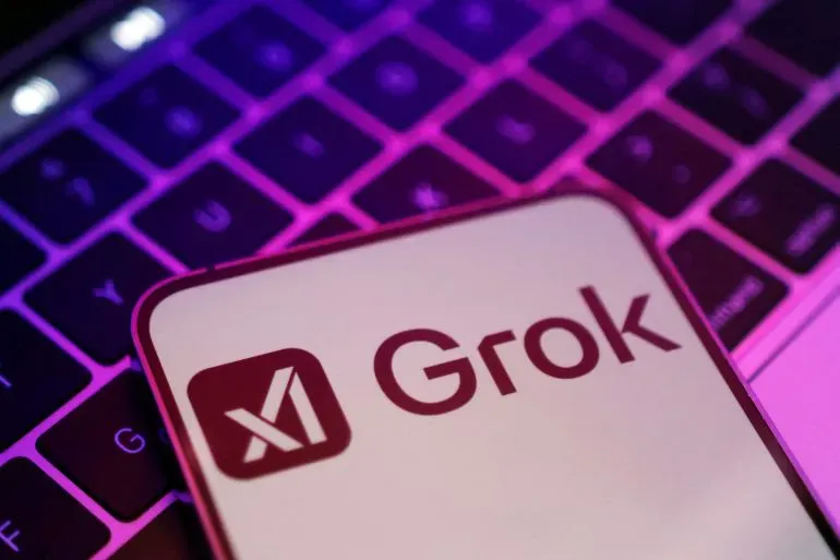 شعار Grok من شركة xAI، يظهر على شاشة كمبيوتر محمول مع إضاءة خلفية ملونة، في سياق الجدل حول الذكاء الاصطناعي.