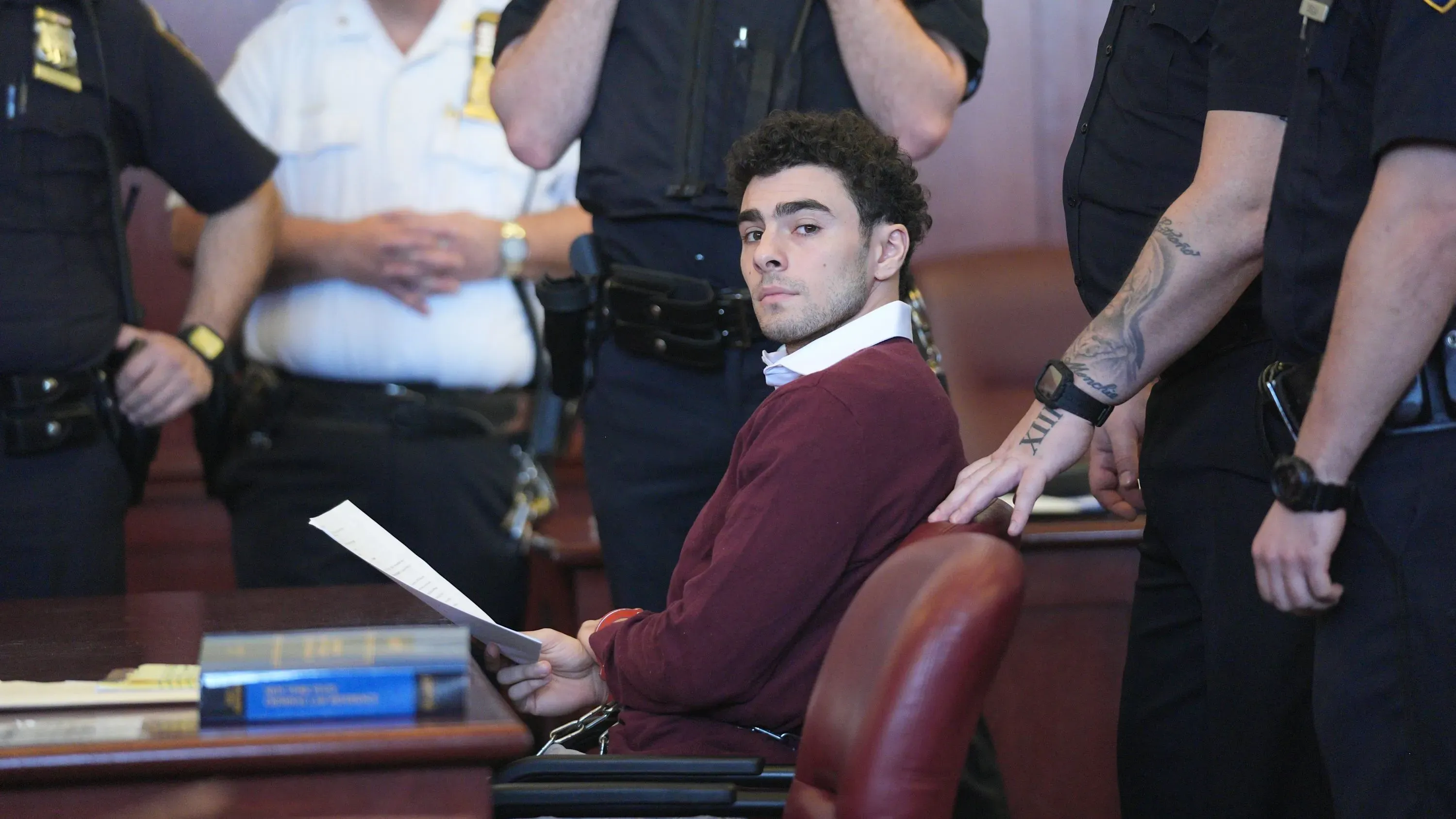 لويجي مانجيوني، المتهم بقتل براين تومبسون، يجلس في قاعة المحكمة محاطًا بالشرطة، حيث يواجه دعمًا شعبيًا غير معتاد.