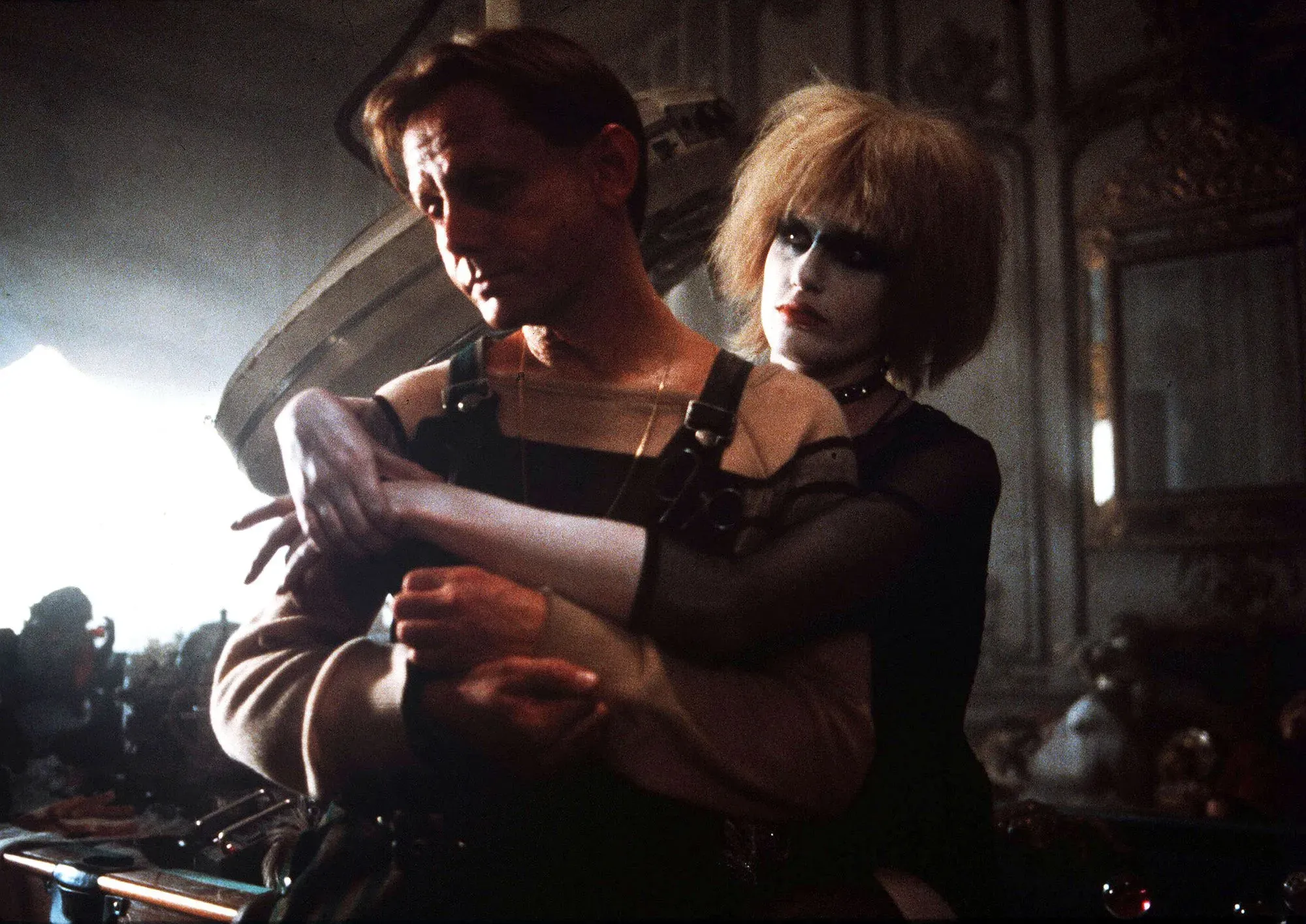 مشهد من فيلم "بليد رانر" يظهر شخصيتين رئيسيتين في بيئة غامضة، يعكس أجواء الفيلم المستقبلية والتوتر الدرامي.