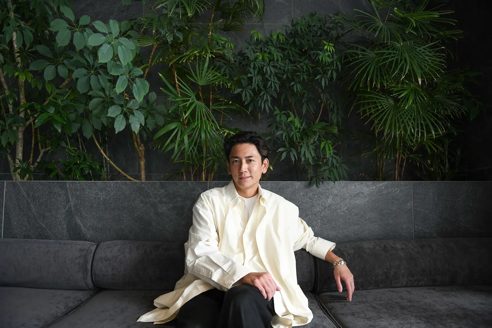 شينسوكي ساكيموتو، الرئيس التنفيذي لشركة فالوينس، يجلس في مكتب حديث محاط بالنباتات، معبراً عن شغفه بعالم الموضة والاستثمار.