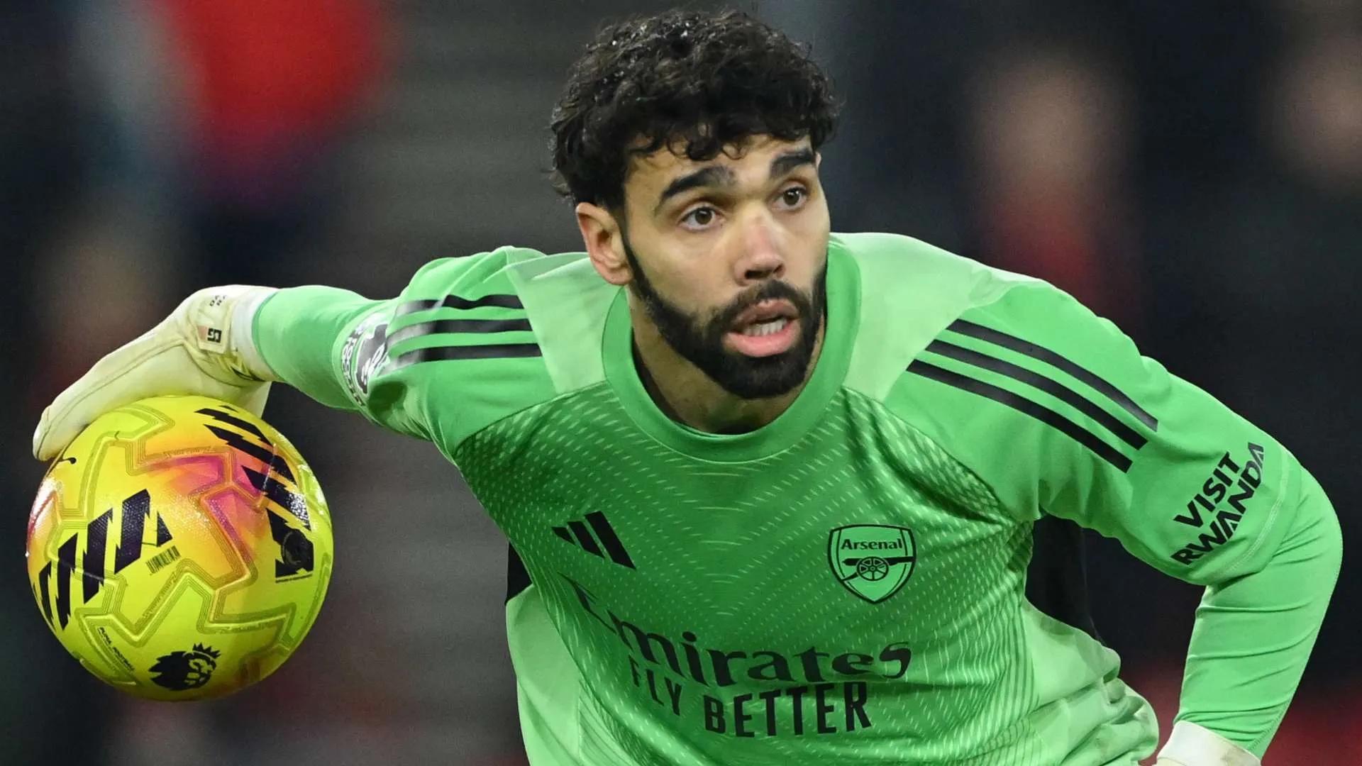 ديفيد رايا حارس مرمى أرسنال يرتدي زي الحارس الأخضر ويحمل كرة قدم صفراء خلال مباراة في الدوري الإنجليزي الممتاز.