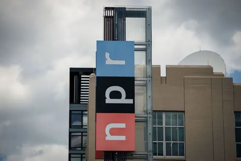 لافتة تحمل شعار NPR على مبنى حديث، تعكس أهمية التمويل الفيدرالي في دعم وسائل الإعلام العامة.