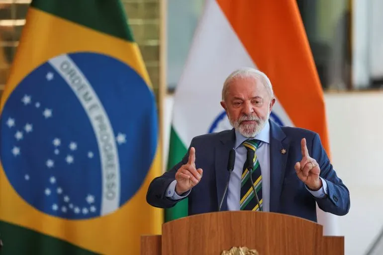 لولا دا سيلفا، رئيس البرازيل، يتحدث في مؤتمر صحفي، مع العلم الوطني البرازيلي خلفه، معبراً عن موقفه من تهديدات ترامب.