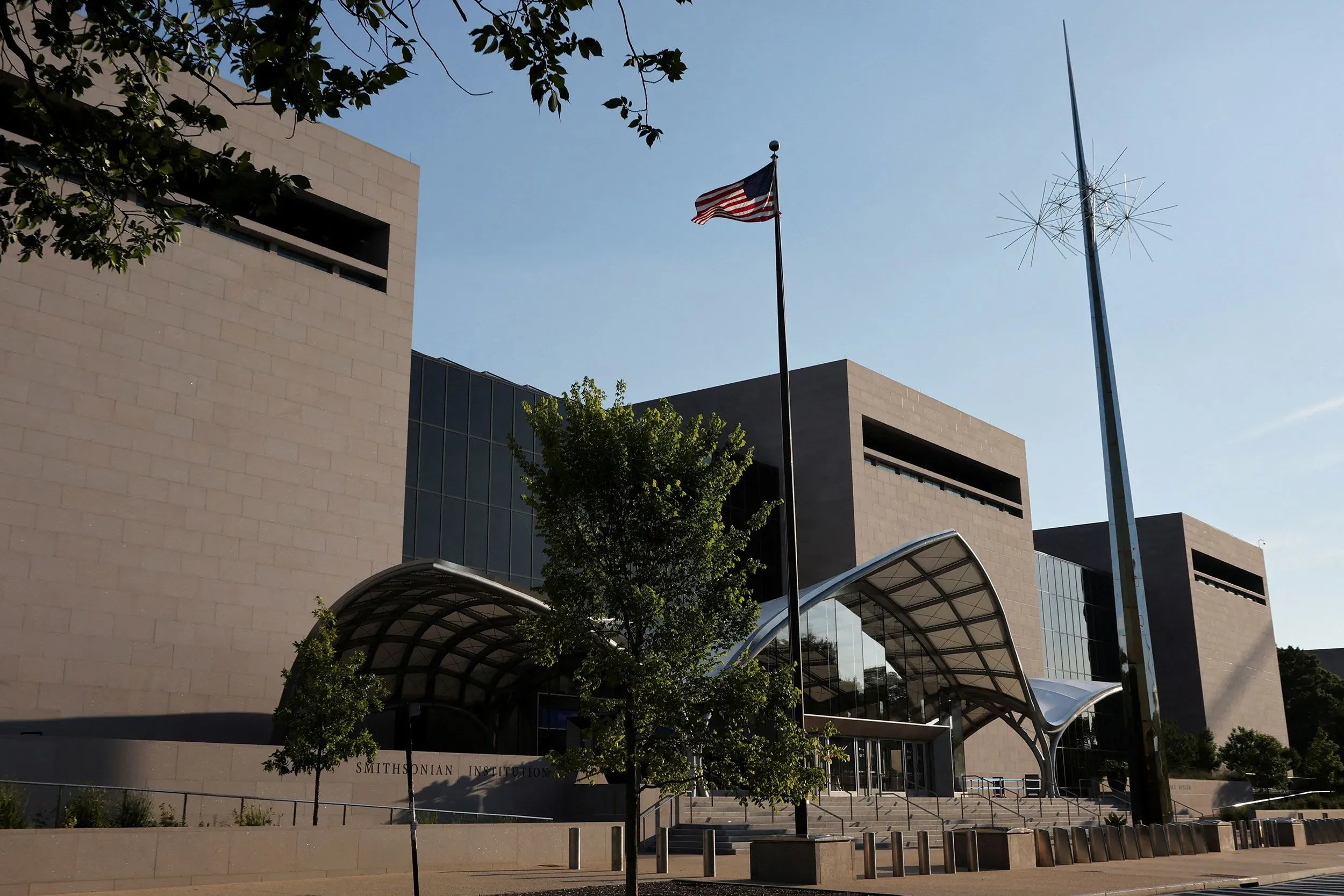 واجهة متحف سميثسونيان في واشنطن، مع علم الولايات المتحدة وشجرة، تعكس جهود المراجعة الداخلية للمؤسسة لتلبية توجيهات البيت الأبيض.