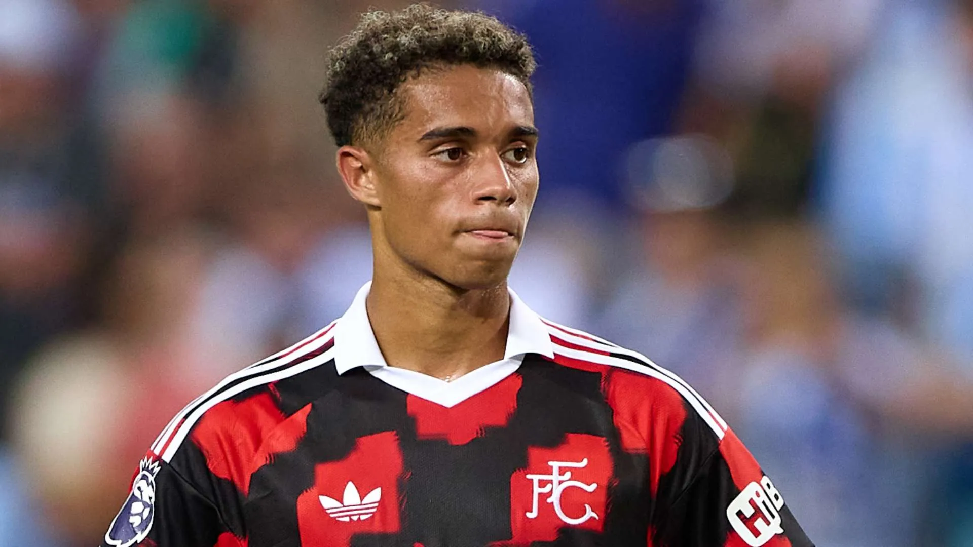 لاعب كرة قدم شاب من أكاديمية فولهام يرتدي زي الفريق خلال مباراة في الدوري الإنجليزي الممتاز، معبرًا عن ولائه وطموحه للنادي.