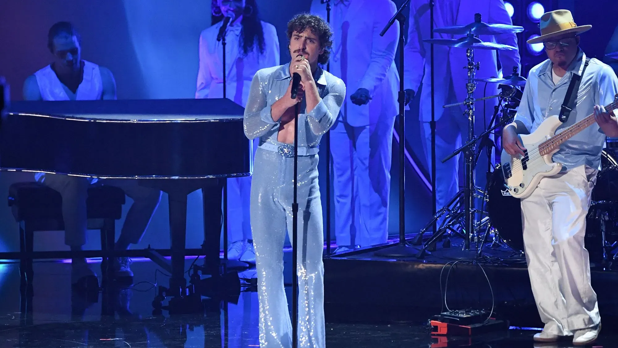 بنسون بون يؤدي أغنيته "Beautiful Things" في حفل الجرامي، مرتديًا بذلة زرقاء لامعة، وسط تفاعل حماسي من الجمهور.