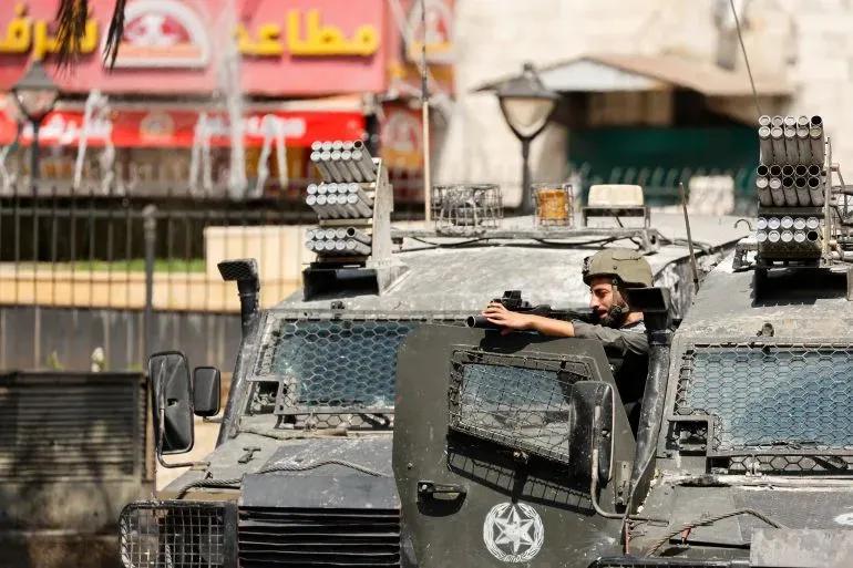 عناصر من الجيش الإسرائيلي داخل مركبات مدرعة، خلال الإغلاق العسكري في الضفة الغربية، مما يعكس تصاعد التوترات في المنطقة.