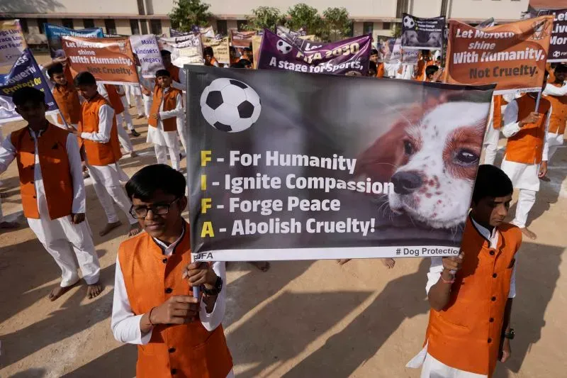 شباب يرتدون زيًا برتقاليًا يحملون لافتة تدعو إلى الإنسانية ووقف القسوة ضد الحيوانات، بالتزامن مع الاستعدادات لكأس العالم 2030.