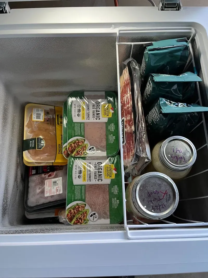 مجمد يحتوي على لحوم ومواد غذائية متنوعة، بما في ذلك الدجاج واللحم المفروم، يعكس اتجاه البستنة الذاتية والتخزين الغذائي.