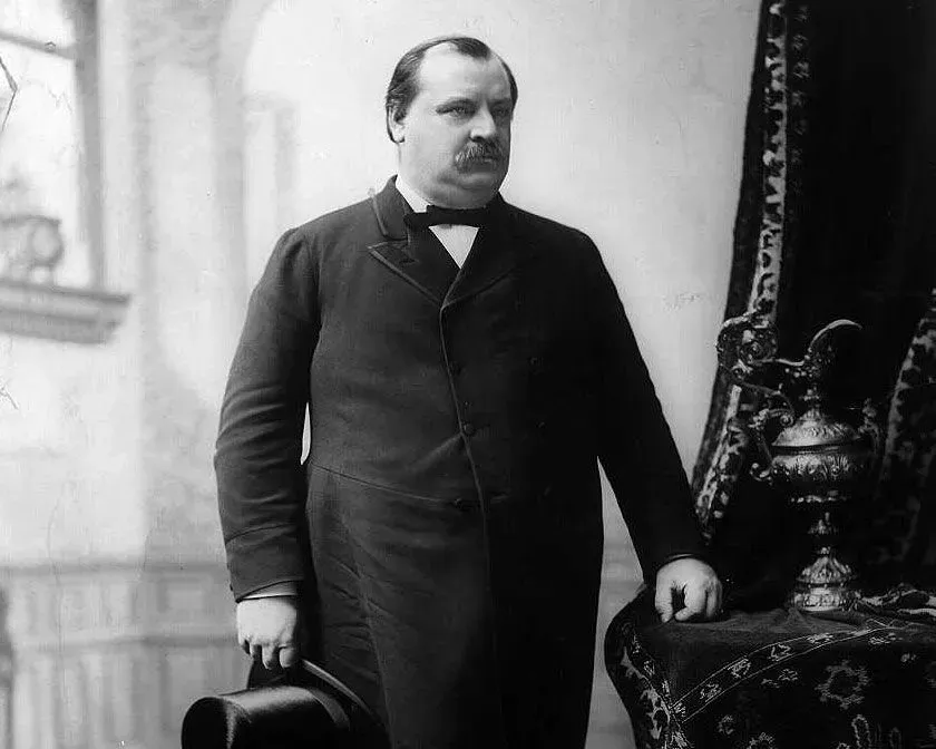 غروفر كليفلاند، الرئيس الأمريكي رقم 22 و24، يقف في صورة تاريخية، مع التركيز على ملامحه وملابسه الرسمية، في سياق مناقشة حول دوره في إرسال القوات الأمريكية.