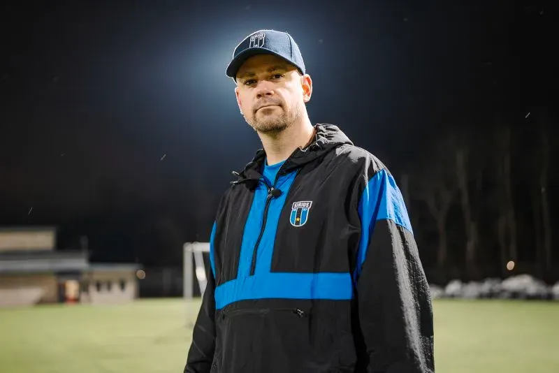 روبرت واير هاغ، قس ولاعب كرة قدم سابق، يقف في ملعب غوتسوندا حيث ينظم "كرة القدم الليلية" للشباب، وسط أجواء مظلمة.