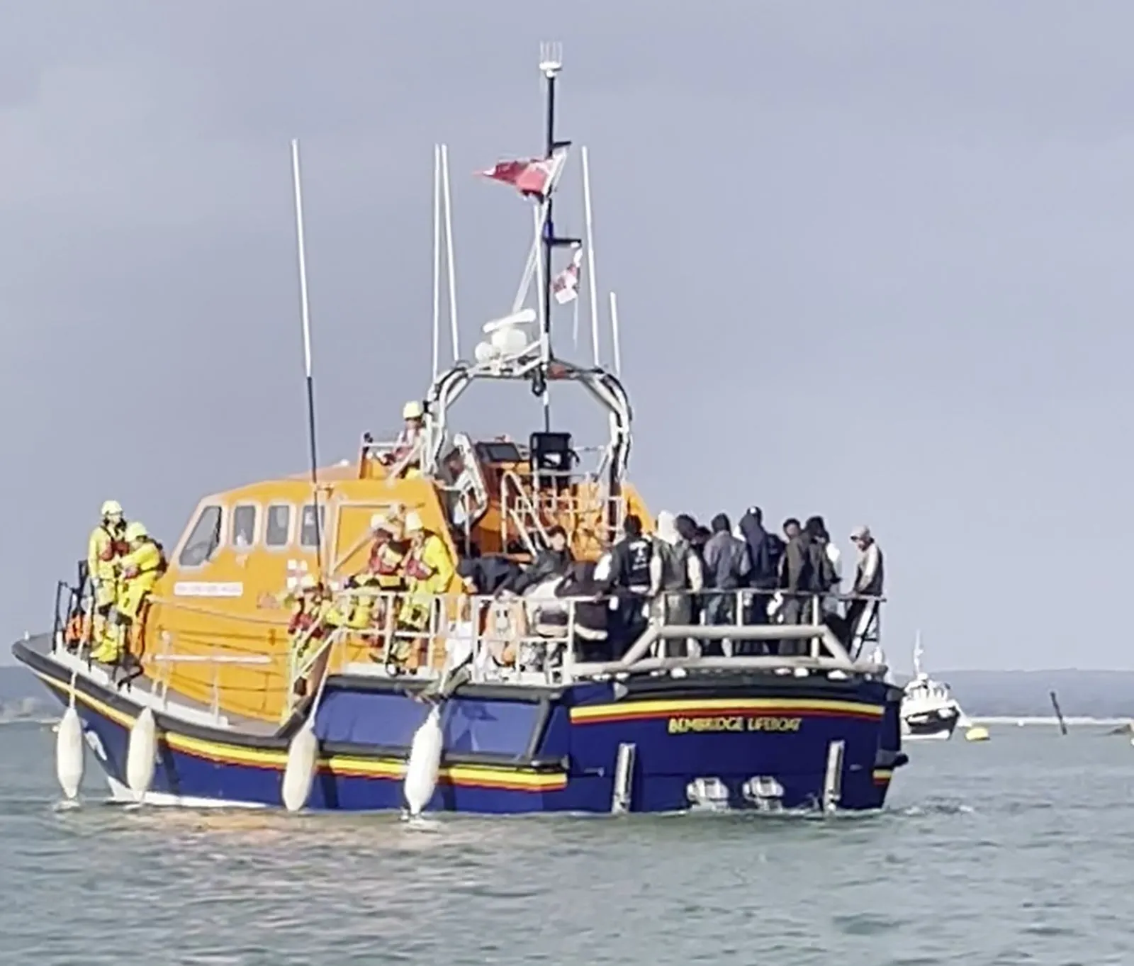 زورق إنقاذ RNLI في بحر المانش يحمل مهاجرين تم إنقاذهم، يعكس جهود المتطوعين في Portsmouth رغم الاحتجاجات والانتقادات.