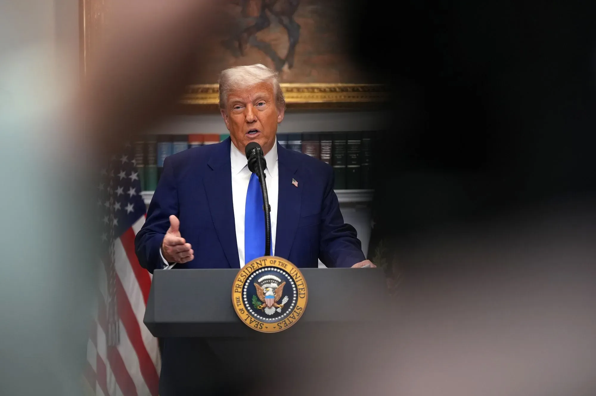 دونالد ترامب يتحدث خلال مؤتمر صحفي، حيث يناقش تمديد إعانات برنامج أوباما كير وسط تحديات سياسية.