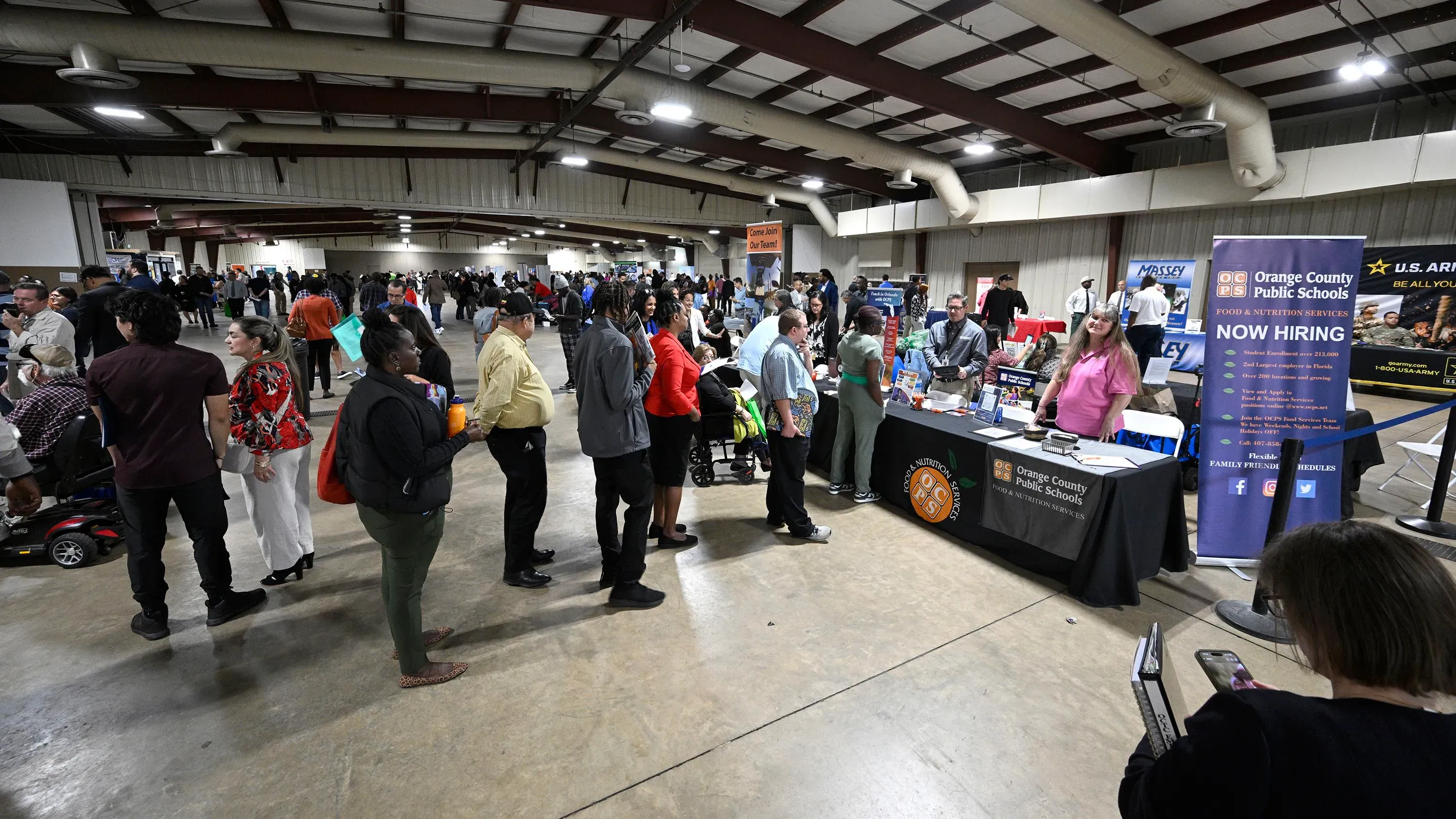 حضور كبير للباحثين عن عمل في معرض توظيف، مع تواجد عدة شركات تعرض فرص العمل المتاحة.