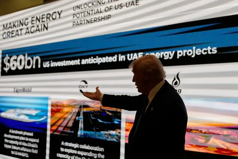 ترامب يتحدث أمام شاشة تعرض معلومات عن استثمارات الطاقة الأمريكية في الإمارات، مع التركيز على شراكات الذكاء الاصطناعي.