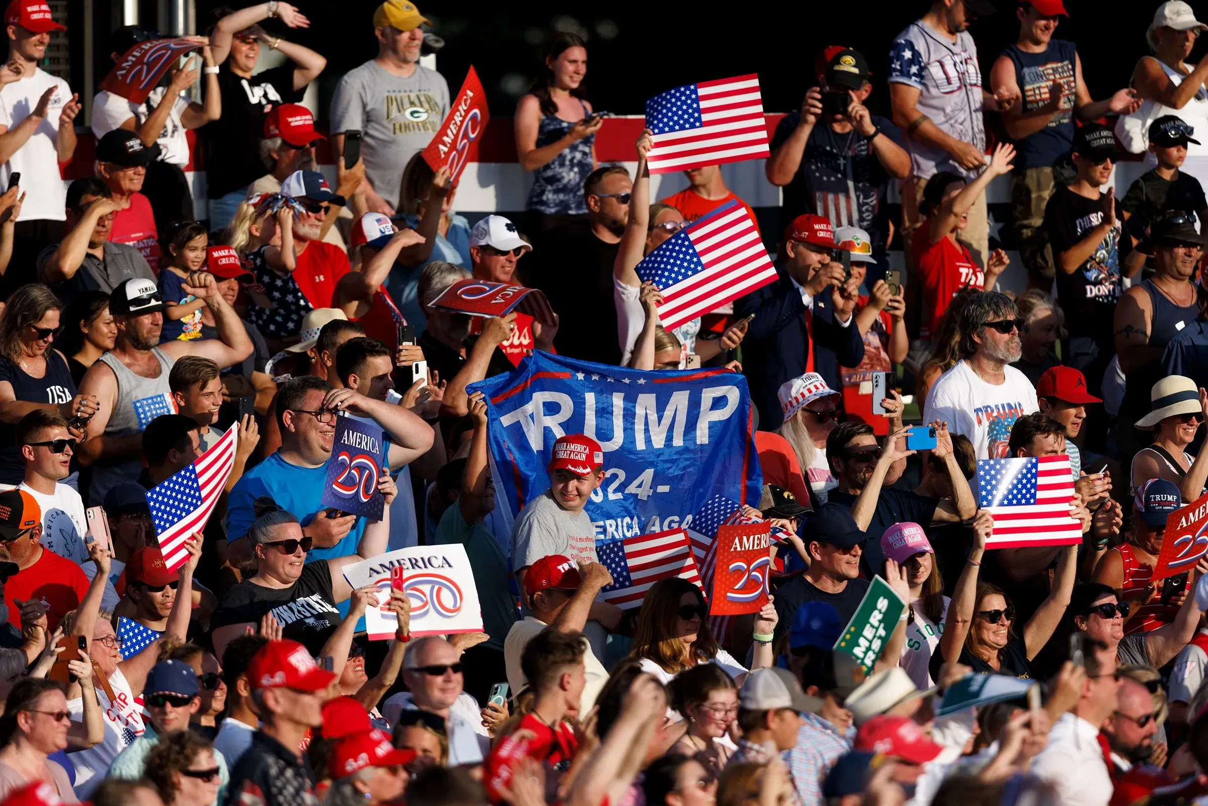 حشد كبير من أنصار ترامب في تجمع انتخابي، يحملون لافتات وأعلام أمريكية، تعبيرًا عن الحماس للاحتفال بالذكرى الـ250 لتأسيس البلاد.