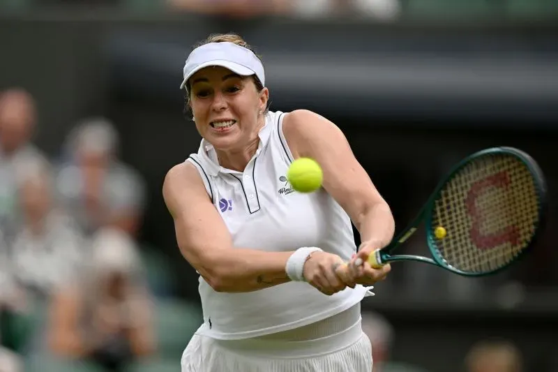 لاعبة تنس تضرب الكرة خلال مباراة في بطولة ويمبلدون، حيث كانت هناك مشكلات في نظام النداء الإلكتروني أثارت جدلاً.