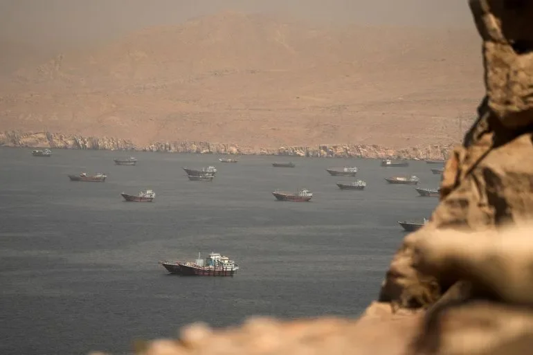 سفن نفط متعددة تعبر مضيق هرمز وسط جبال جافة، مع استئناف حركة الملاحة وتأثيرها على أسعار النفط العالمية.
