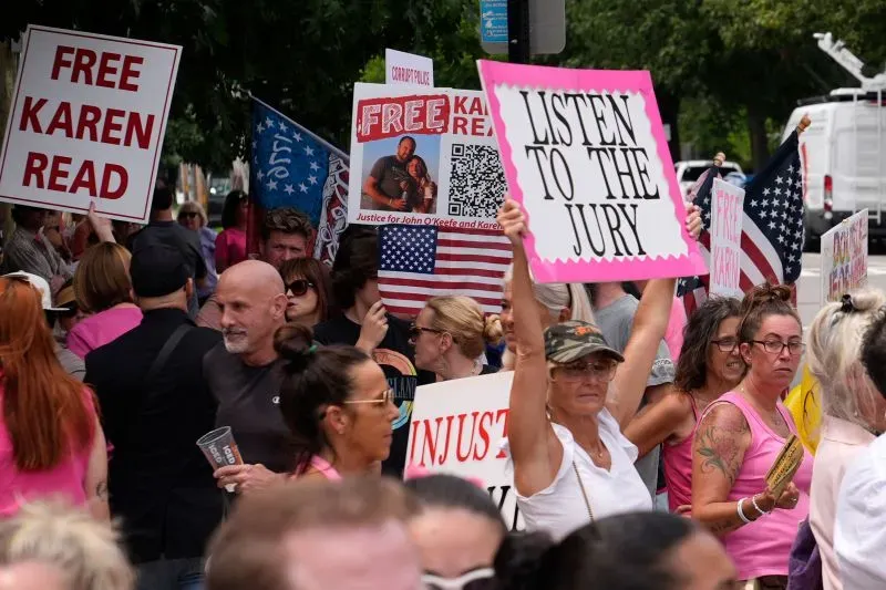 مظاهرة أمام المحكمة لدعم كارين ريد، حيث يحمل المشاركون لافتات تطالب بالعدالة، مع ارتداء معظمهم ملابس وردية.