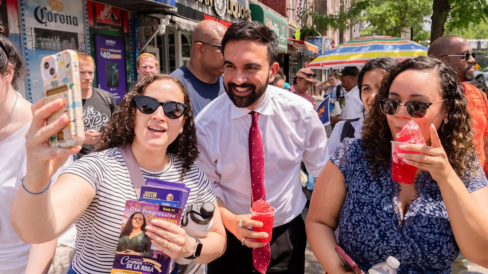 زهران ممداني يتفاعل مع مؤيديه في شوارع نيويورك، حيث يوزع المنشورات ويظهر حماسًا خلال حملته الانتخابية لرئاسة البلدية.