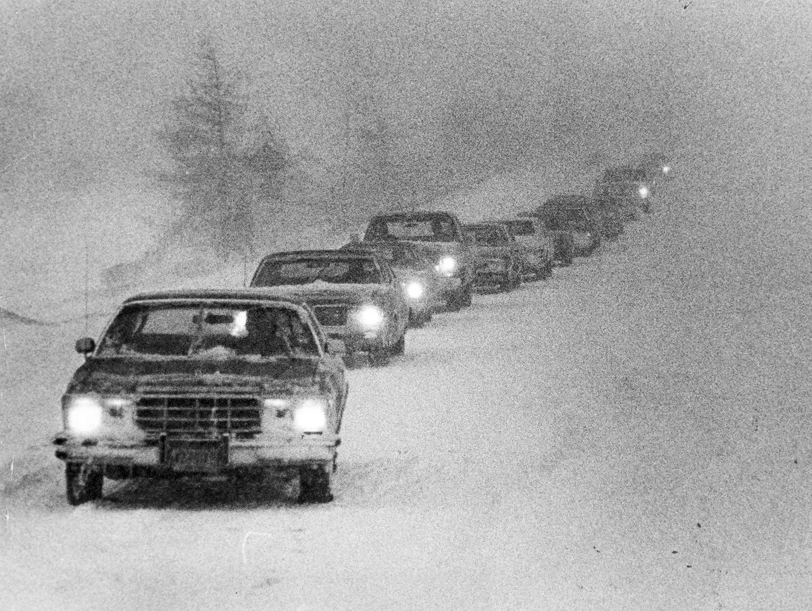 طابور من السيارات عالق في عاصفة ثلجية قوية في شمال شرق الولايات المتحدة، حيث تتساقط الثلوج بكثافة وتقل الرؤية.