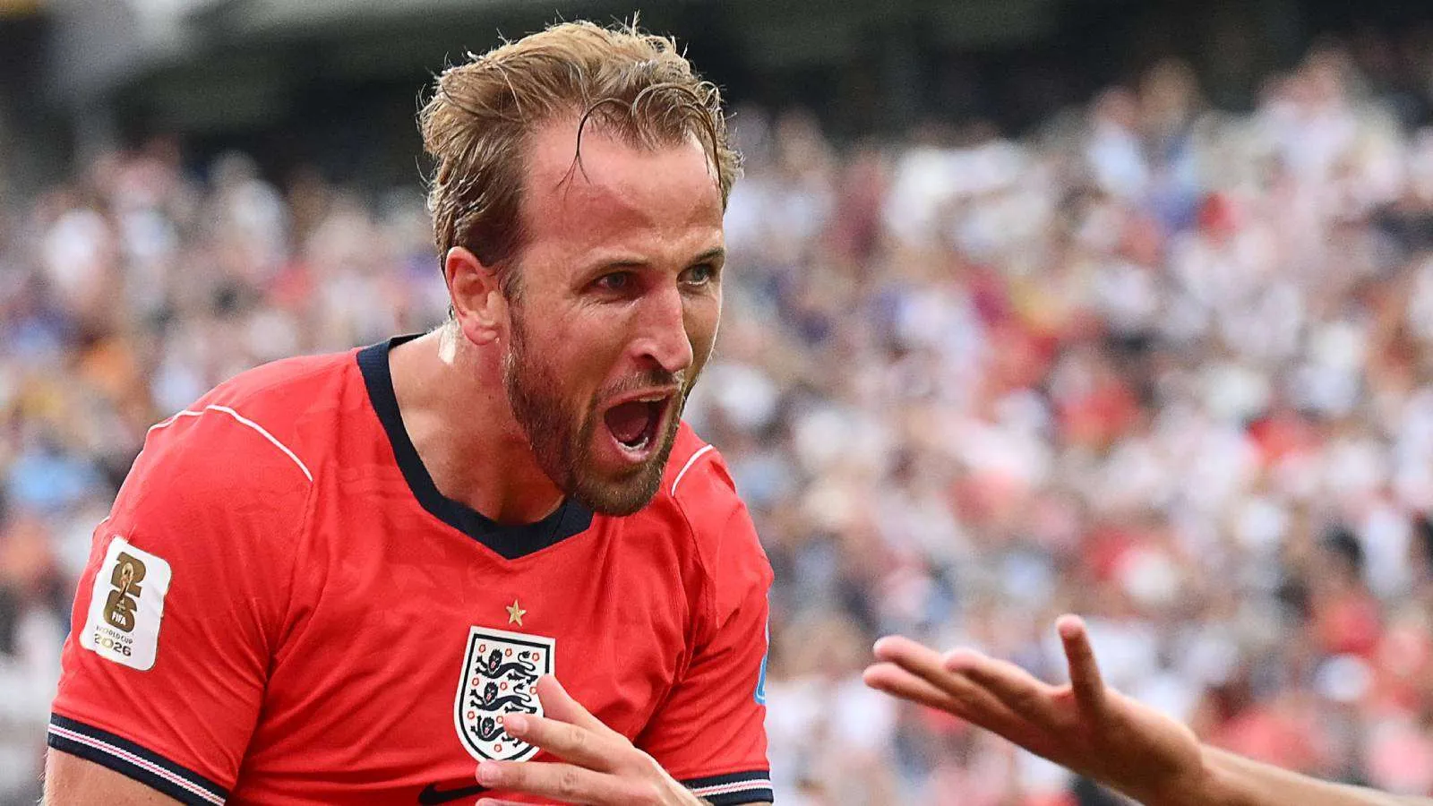 هاري كين يحتفل بحماس بعد تسجيل هدف في كأس العالم 2026، مع جمهور متحمس في الخلفية، في منافسة الحذاء الذهبي.