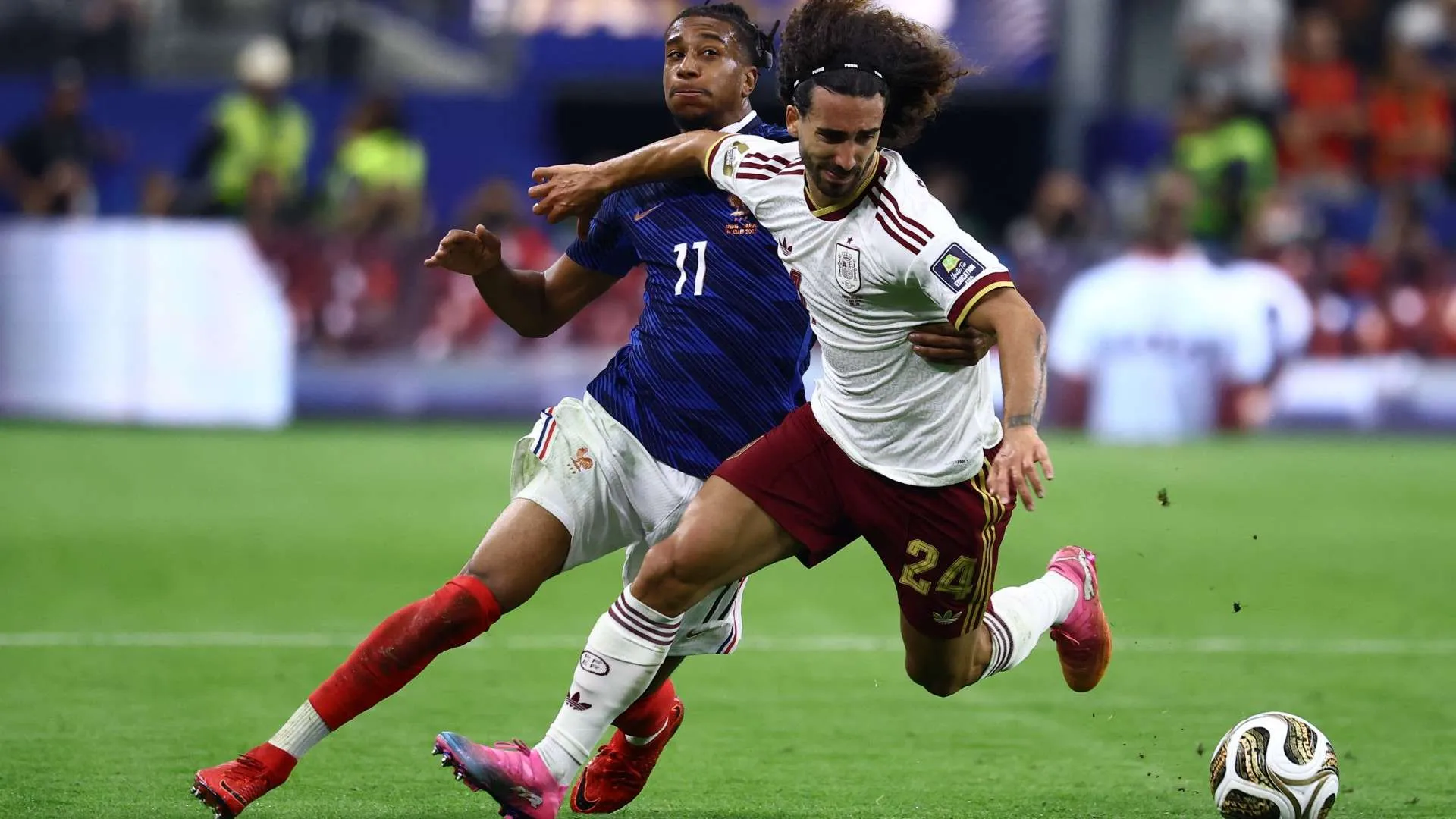 لاعبان من فرنسا وإسبانيا يتنافسان على الكرة خلال مباراة نصف نهائي كأس العالم، تعكس التوتر والإثارة التكتيكية بين الفريقين.