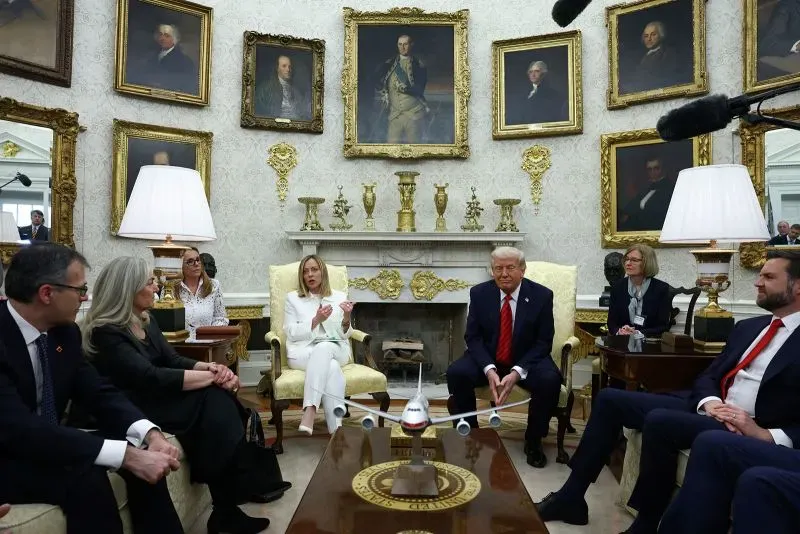 اجتماع في المكتب البيضاوي، يظهر الرئيس ترامب مع مستشارين، بينما تتزين الجدران باللوحات التاريخية. يتناول النقاش قضايا سياسية حساسة.