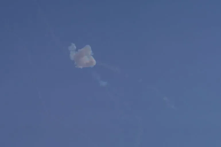 سحابة دُخانية تتصاعد في السماء الزرقاء، تشير إلى تصعيد عسكري في الصراع بين إيران والولايات المتحدة وإسرائيل.