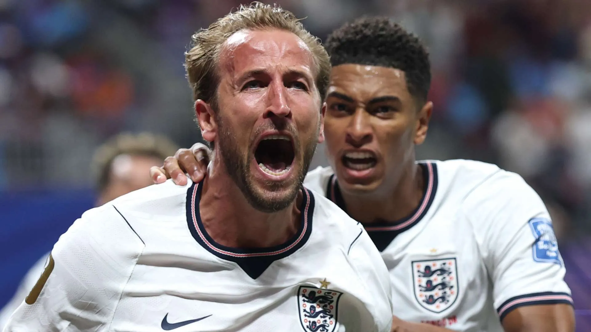 هاري كين يحتفل بحماس بعد تسجيل هدف مع منتخب إنجلترا، مع زميله خلفه في مباراة دولية لكرة القدم.