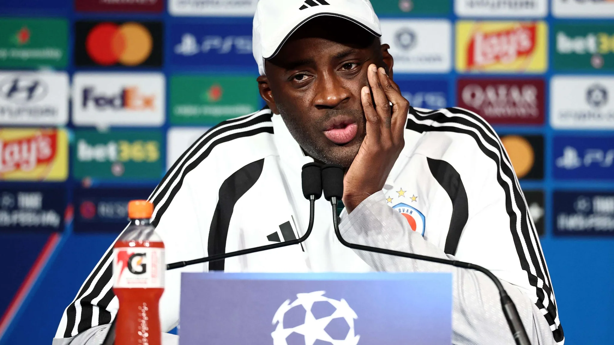 ياية توريه يرتدي زي فريق سلوفان براتيسلافا خلال مؤتمر صحفي لدوري أبطال أوروبا، كأول مدرب أفريقي يقود فريقاً في البطولة.