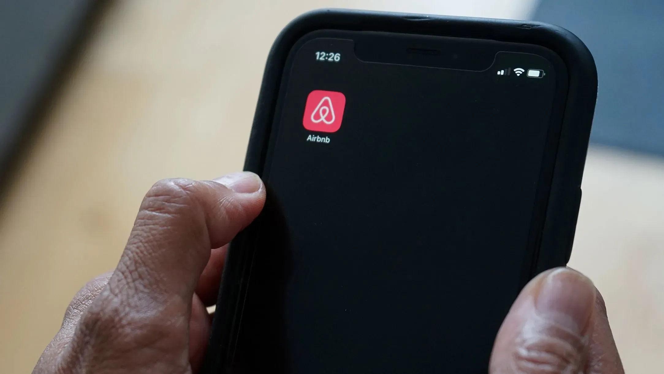 تطبيق Airbnb مفتوح على شاشة هاتف ذكي، مع التركيز على أيقونة التطبيق، مما يعكس التحديثات الجديدة والخدمات المتاحة للمستخدمين.