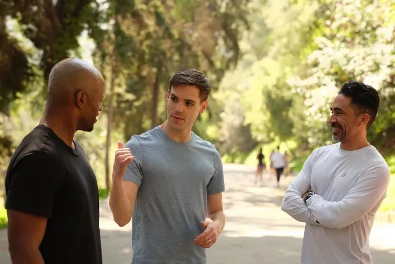 ثلاثة رجال يتحدثون في ممر طبيعي، يعبرون عن آرائهم حول السياسة والديمقراطيين الشباب في إنديانا.