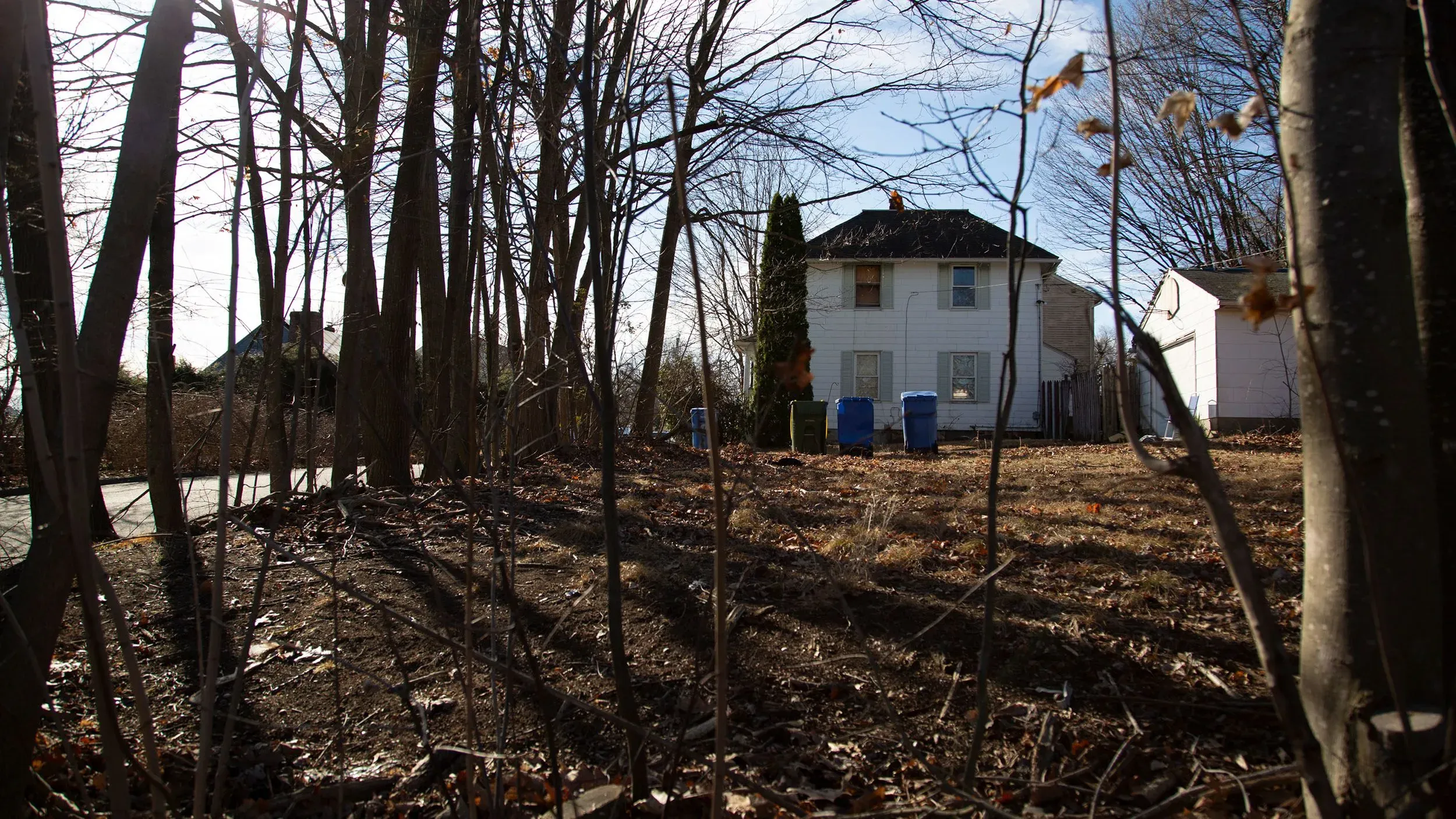 منزل في ولاية كونيتيكت محاط بالأشجار، يُظهر خلفية القصة المؤلمة لرجل عانى من الأسر وسوء المعاملة لأكثر من 20 عامًا.